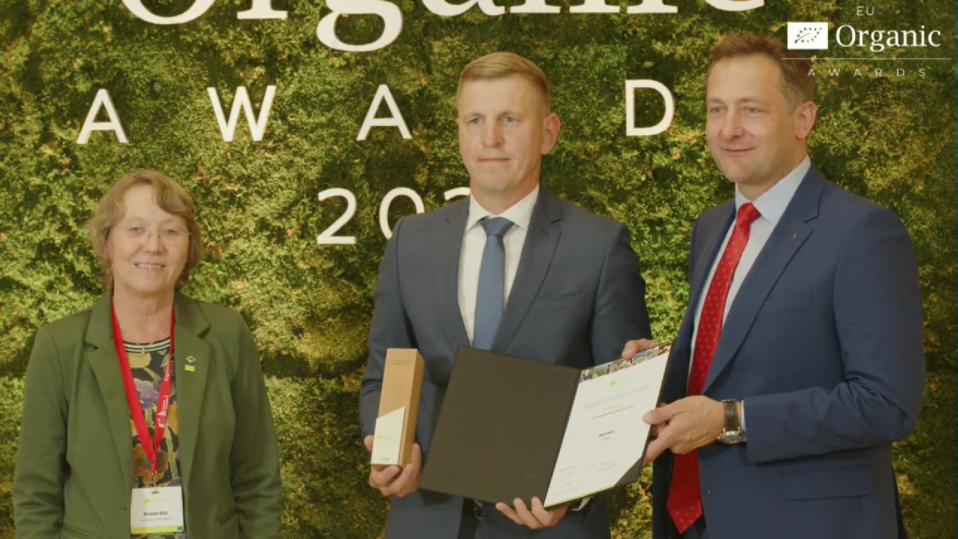 Võrumaa Arenduskeskuse juhatuse liige Tiit Toots (keskel) Võru maakonna nimel Euroopa Liidu mahepiirkond 2025 tiitlit vastu võtmas.